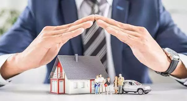 A person creating a house with their hands, with a small house, family, and car beneath.